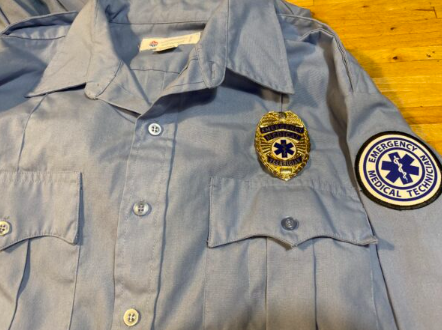 EMT medical technician light blue uniform shirt with gold badge and Emergency Medical Technician patch