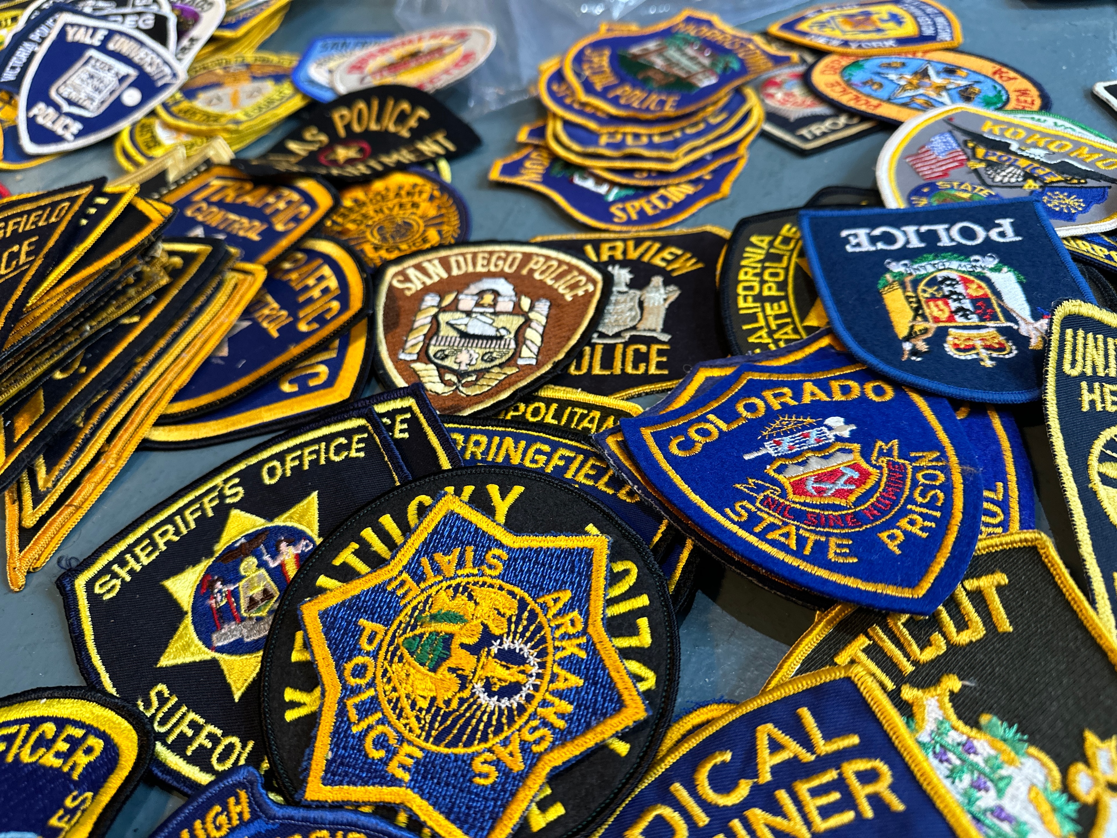 Large selection of vintage police patches from departments across the United States including San Diego Police, Colorado State Prison, Arkansas Police, Suffolk County, and Yale University Police