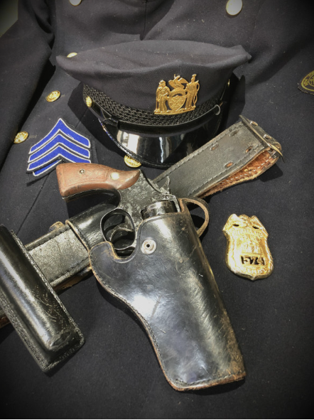 Vintage 1950s-1960s high rank police uniform — cap with gold badge, sergeant chevrons, revolver in holster, and shield badge