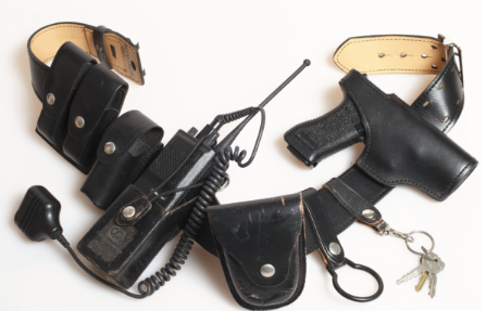 Police duty belt with leather holster, radio, handcuffs, and keys