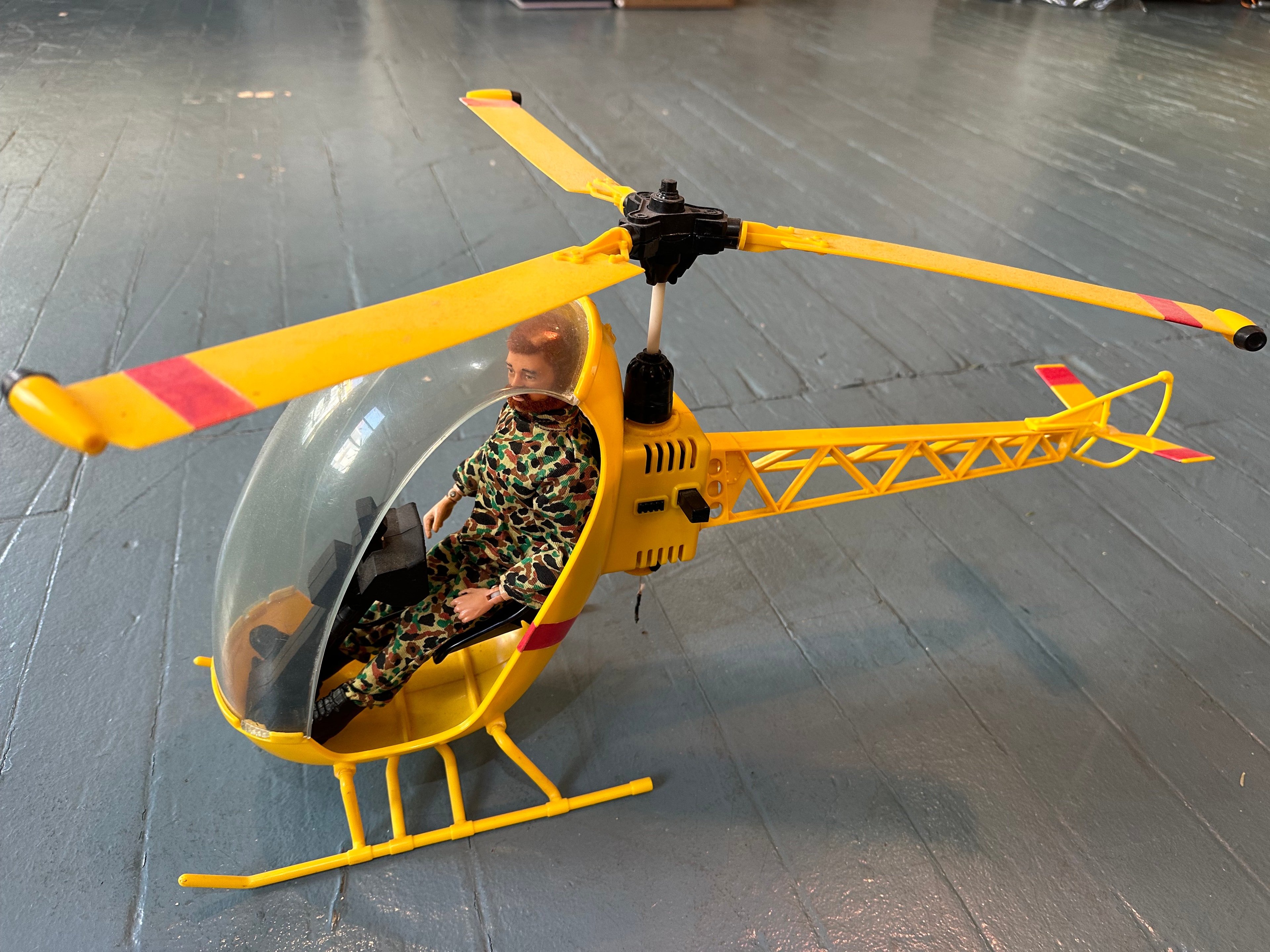 1970s GI Joe yellow helicopter with clear bubble cockpit and GI Joe figure in camouflage seated inside