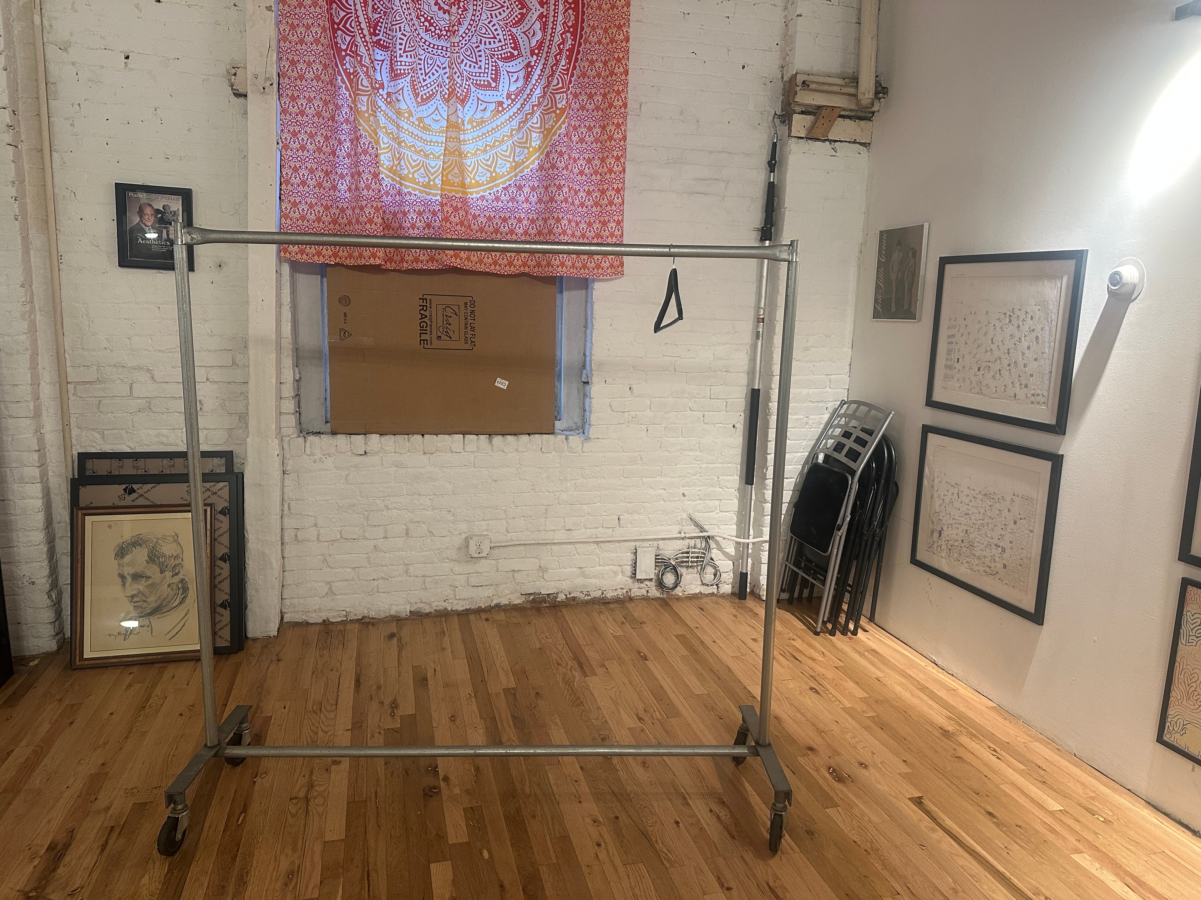 Open rehearsal room with garment rack and artwork