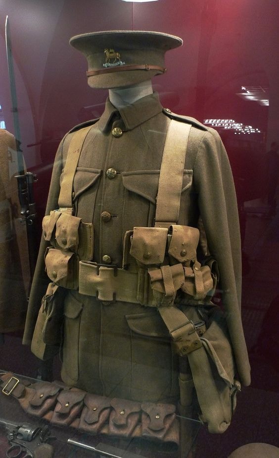 WWII British Army uniform with webbing harness and ammunition pouches on museum display