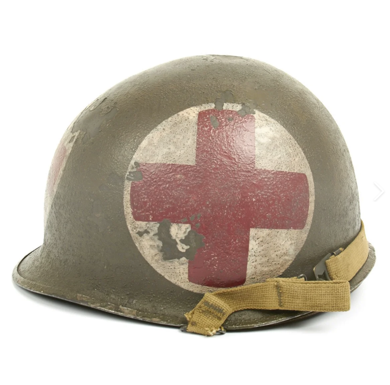 WWII US Army medic M1 steel helmet with red cross on white circle insignia and canvas chin strap